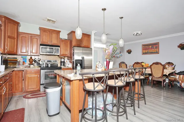 a view of a dining room and livingroom with furniture wooden floor a chandelier