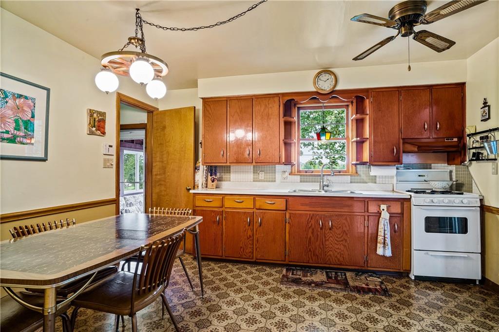 679 Mt Jackson Road New Castle, PA 16102 - Photo 7 of 14 a kitchen with stainless steel appliances granite countertop a stove a sink dishwasher a dining table and chairs with wooden floor