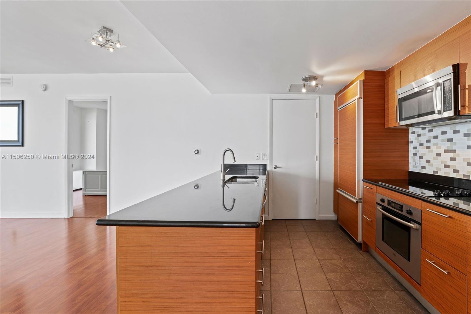 50 Biscayne Boulevard, Unit 3102 Miami, FL 33132 - Photo 12 of 43 a kitchen with stainless steel appliances granite countertop a refrigerator and a stove top oven