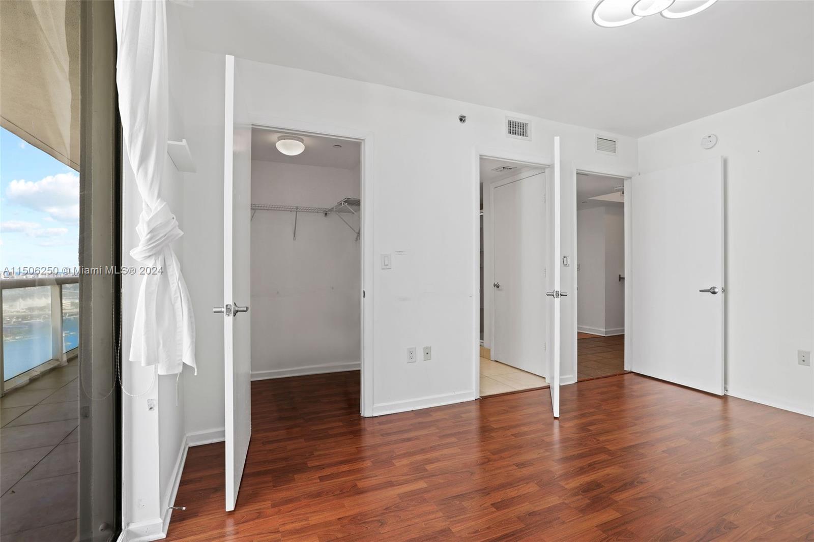 50 Biscayne Boulevard, Unit 3102 Miami, FL 33132 - Photo 15 of 43 a view of an empty room with wooden floor and a bathroom