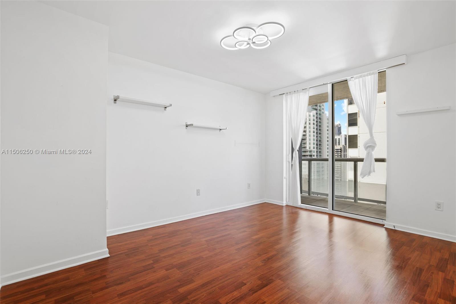 50 Biscayne Boulevard, Unit 3102 Miami, FL 33132 - Photo 24 of 43 an empty room with wooden floor and windows