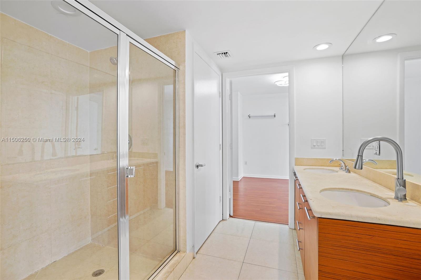 50 Biscayne Boulevard, Unit 3102 Miami, FL 33132 - Photo 25 of 43 a bathroom with a granite countertop sink a mirror and shower