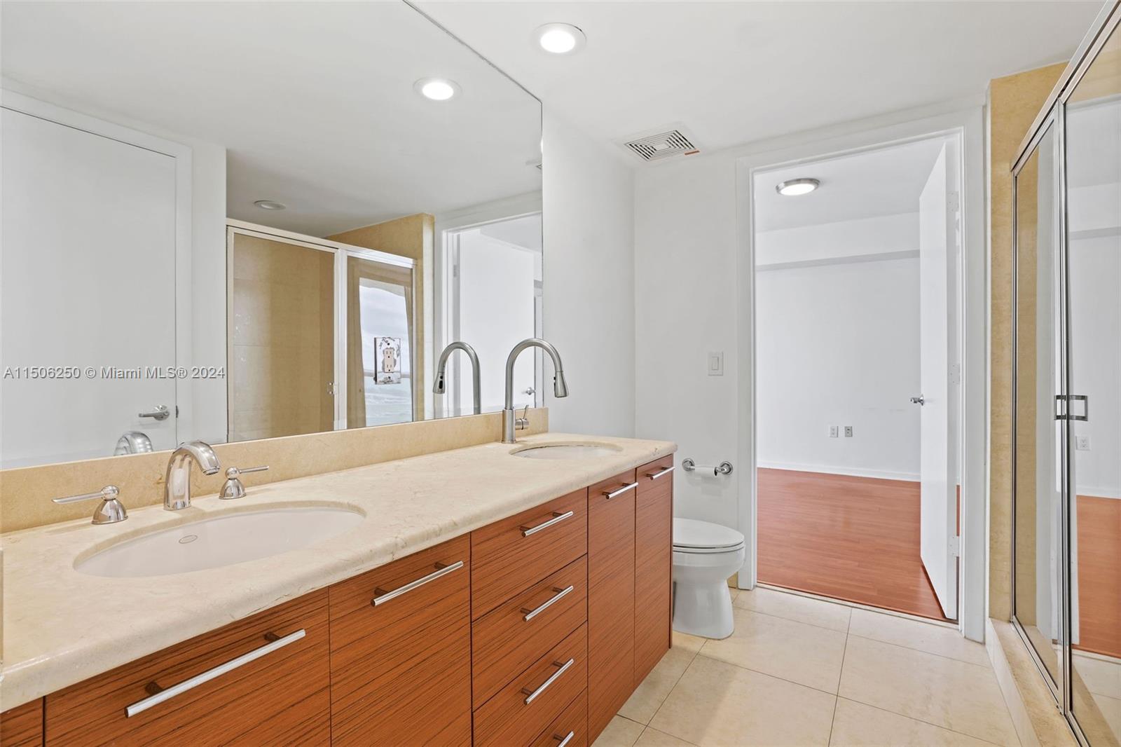 50 Biscayne Boulevard, Unit 3102 Miami, FL 33132 - Photo 26 of 43 a spacious bathroom with a granite countertop sink a toilet and a mirror