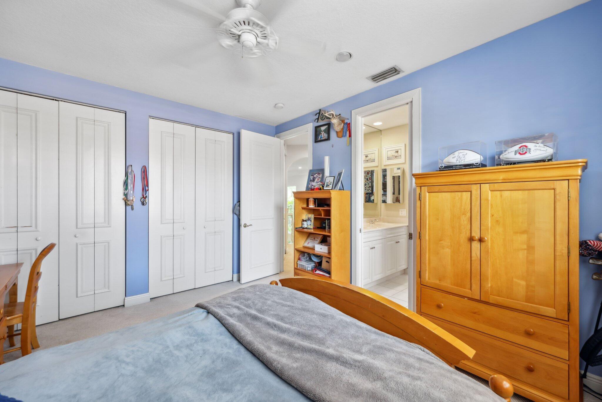 1018 Grand Court Highland Beach, FL 33487 - Photo 54 of 70 a bedroom with a bed and wooden furniture