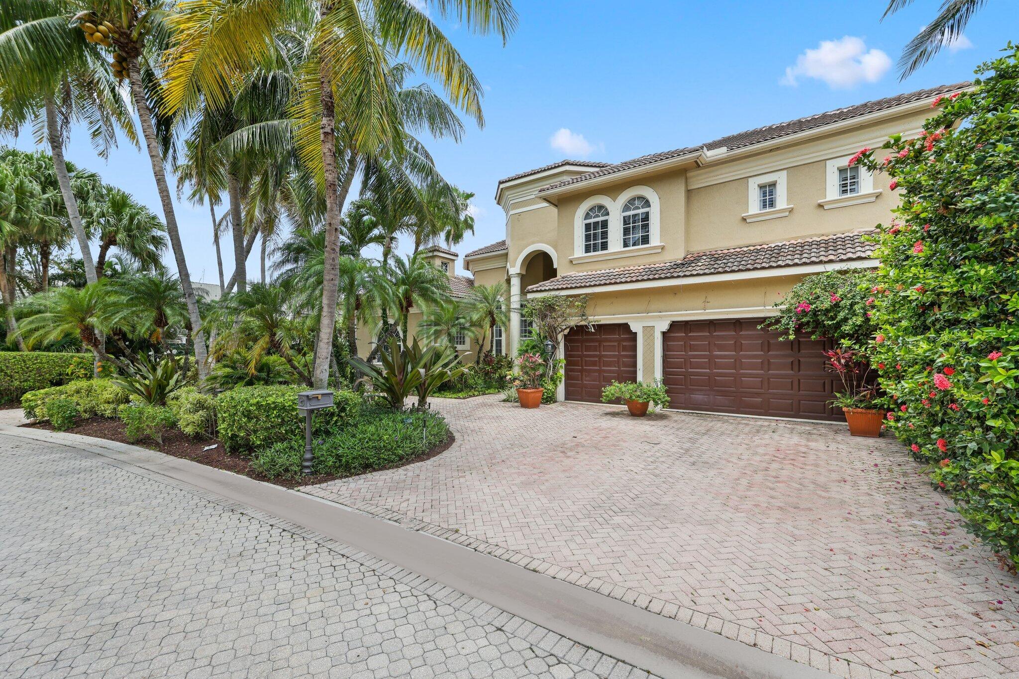 1018 Grand Court Highland Beach, FL 33487 - Photo 6 of 70 a front view of a house with a yard and a garage