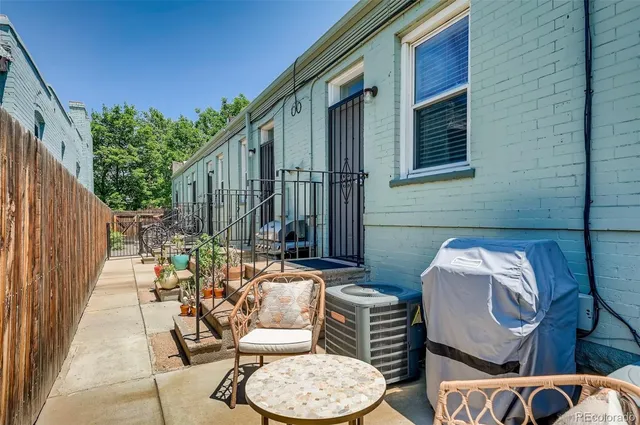 a view of a patio with couple of chairs and a potted plant