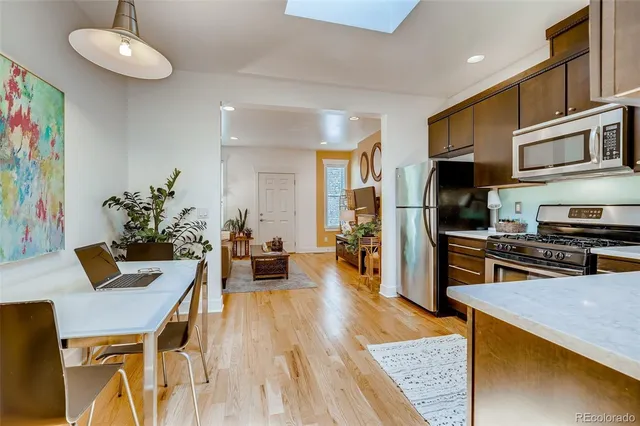 a view of a dining room with furniture a kitchen and chandelier
