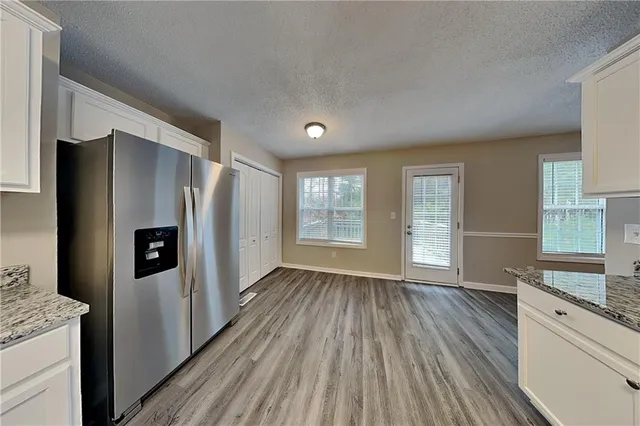 a view of a kitchen with wooden floor and electronic appliances