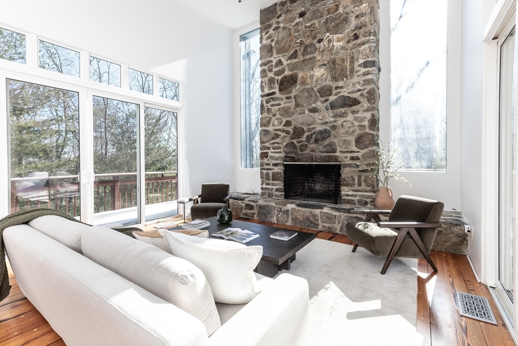 100 Bradford Road Weston, MA 02493 - Photo 12 of 42 a living room with furniture large windows and a fireplace