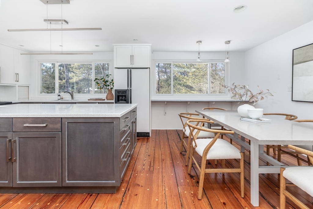 100 Bradford Road Weston, MA 02493 - Photo 18 of 42 a kitchen with stainless steel appliances granite countertop a table chairs in it and wooden floors