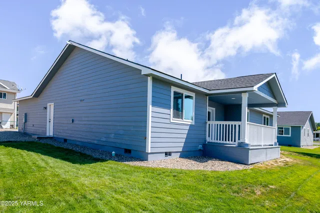a view of a house with a yard and wooden fence
