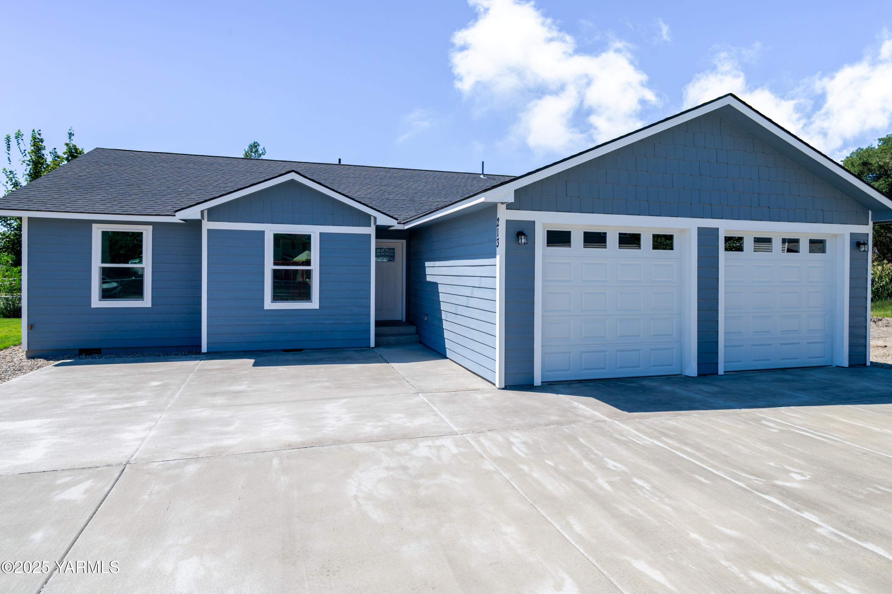 213 3rd Street East Granger, WA 98932 - Photo 2 of 12 a front view of a house with a yard and garage