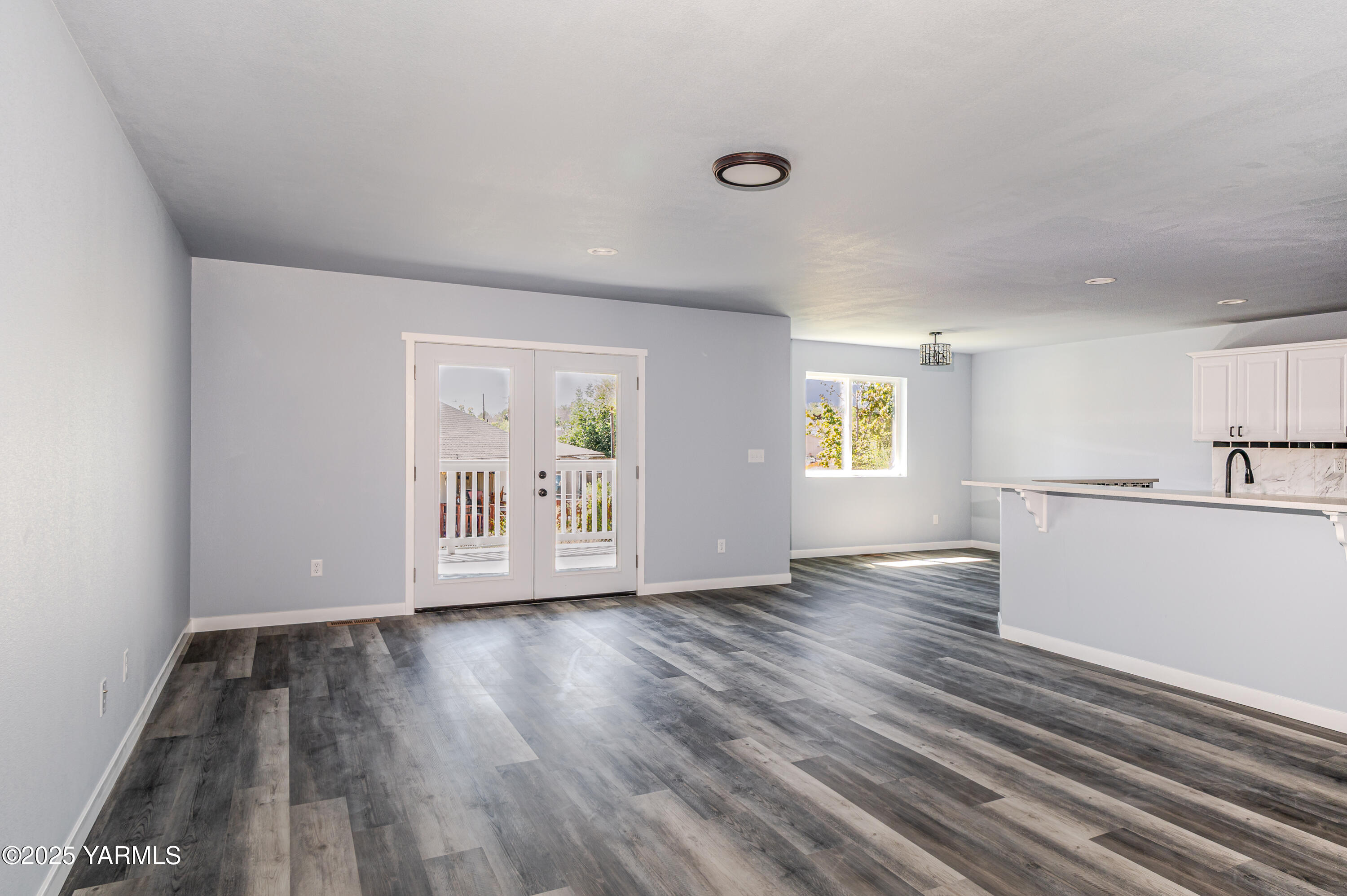 213 3rd Street East Granger, WA 98932 - Photo 3 of 12 a view of an empty room with wooden floor and a window