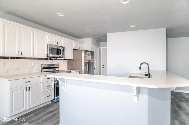 a kitchen with appliances a sink and cabinets