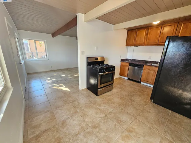 a view of kitchen with stainless steel appliances granite countertop a stove a sink and a refrigerator