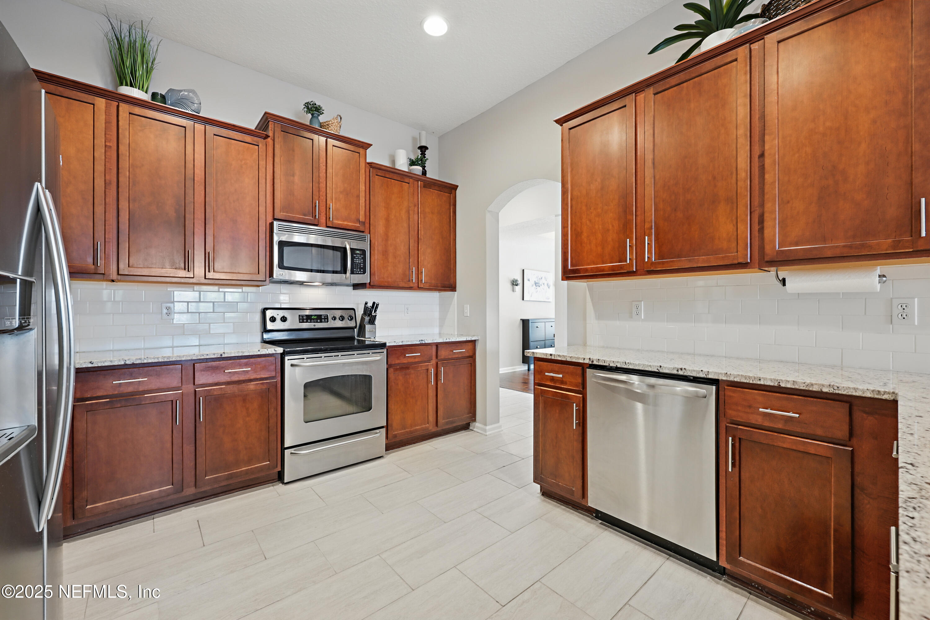 672 Porta Rosa Circle St. Augustine, FL 32092 - Photo 14 of 42 a kitchen with stainless steel appliances granite countertop a stove top oven a sink dishwasher and cabinets with wooden floor