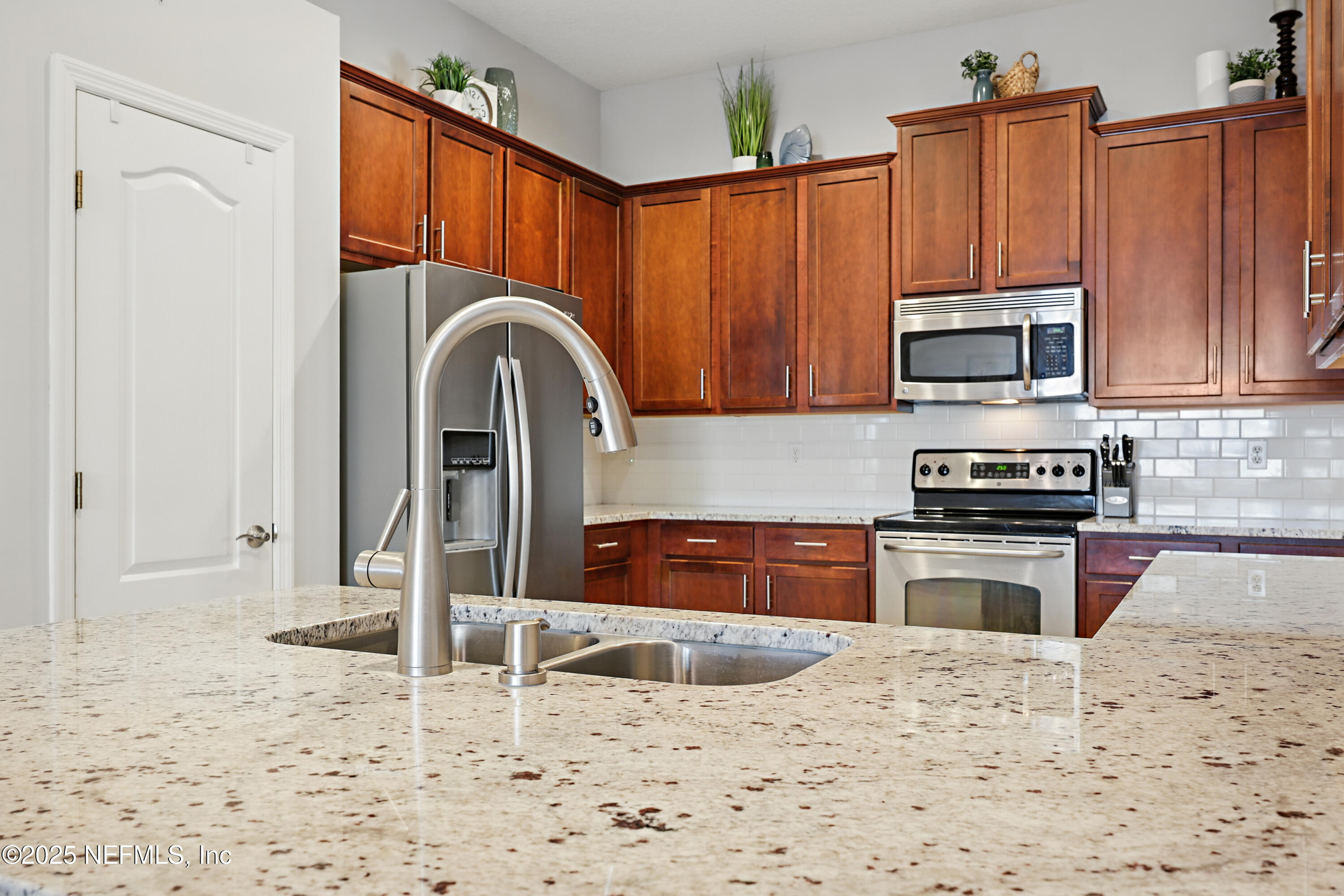 672 Porta Rosa Circle St. Augustine, FL 32092 - Photo 15 of 42 a kitchen with stainless steel appliances granite countertop a stove a sink and a microwave