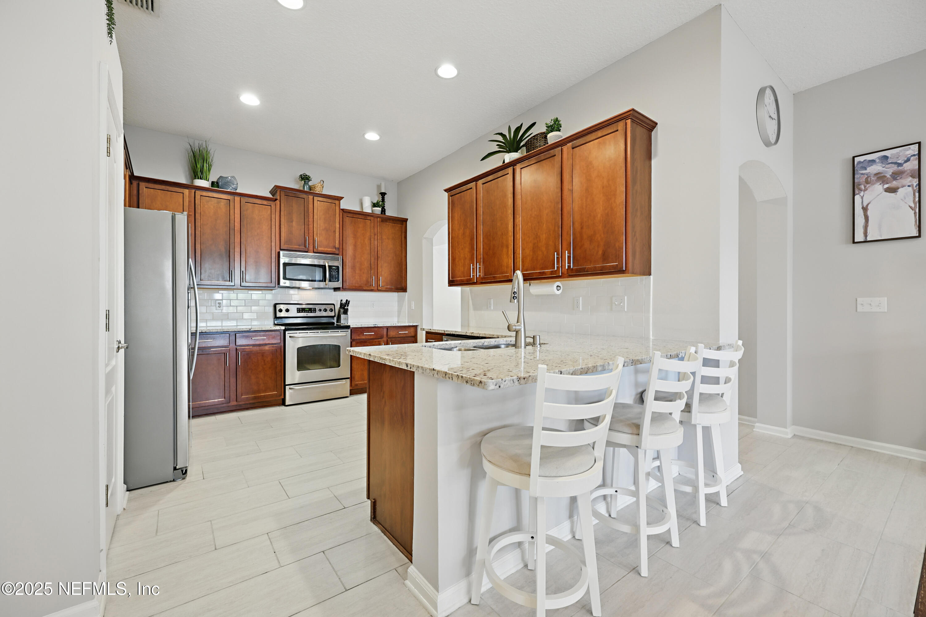 672 Porta Rosa Circle St. Augustine, FL 32092 - Photo 18 of 42 a kitchen with stainless steel appliances granite countertop a stove top oven a sink a dining table and chairs