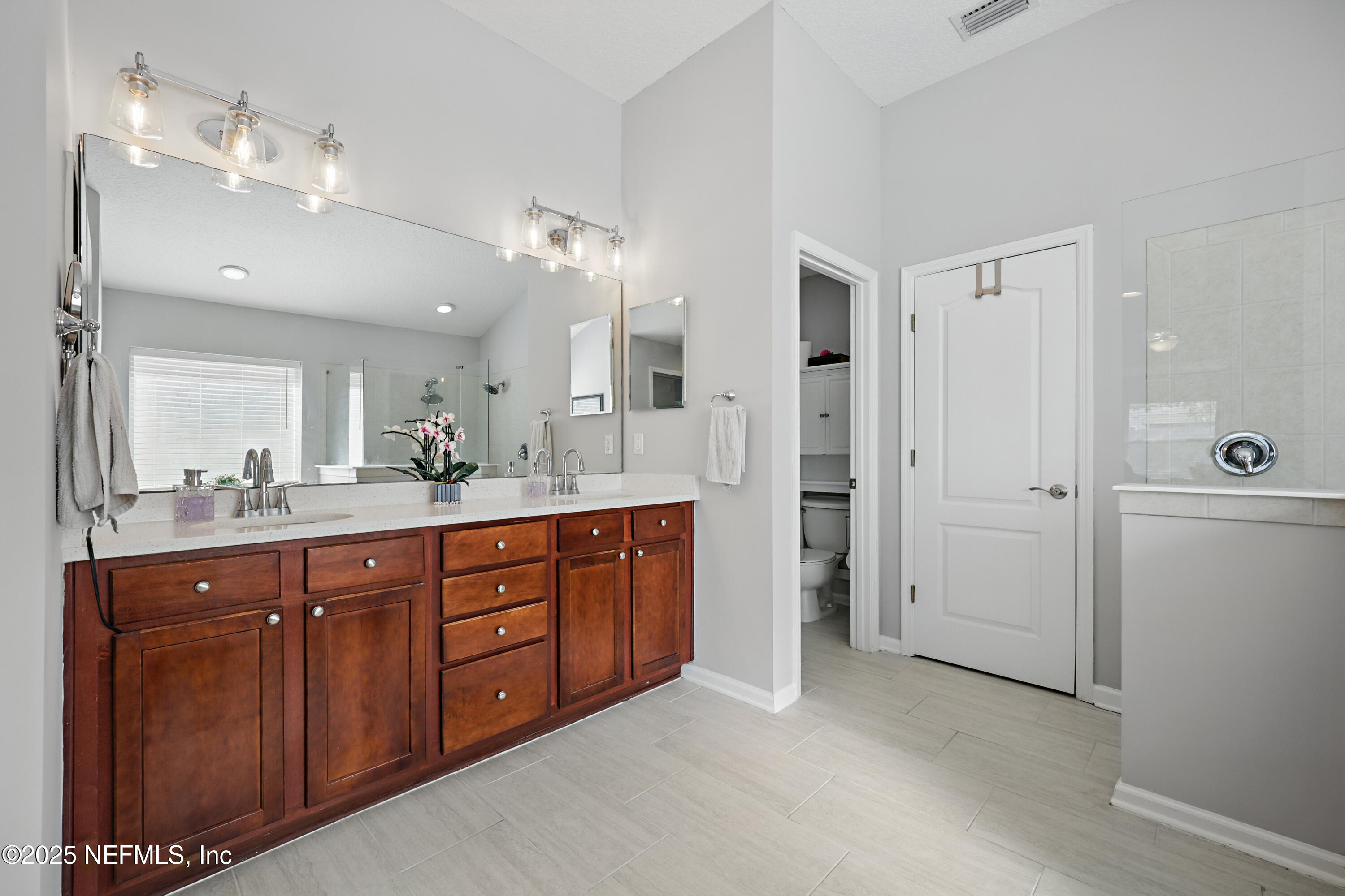 672 Porta Rosa Circle St. Augustine, FL 32092 - Photo 21 of 42 a spacious bathroom with a double vanity sink a large mirror and shower