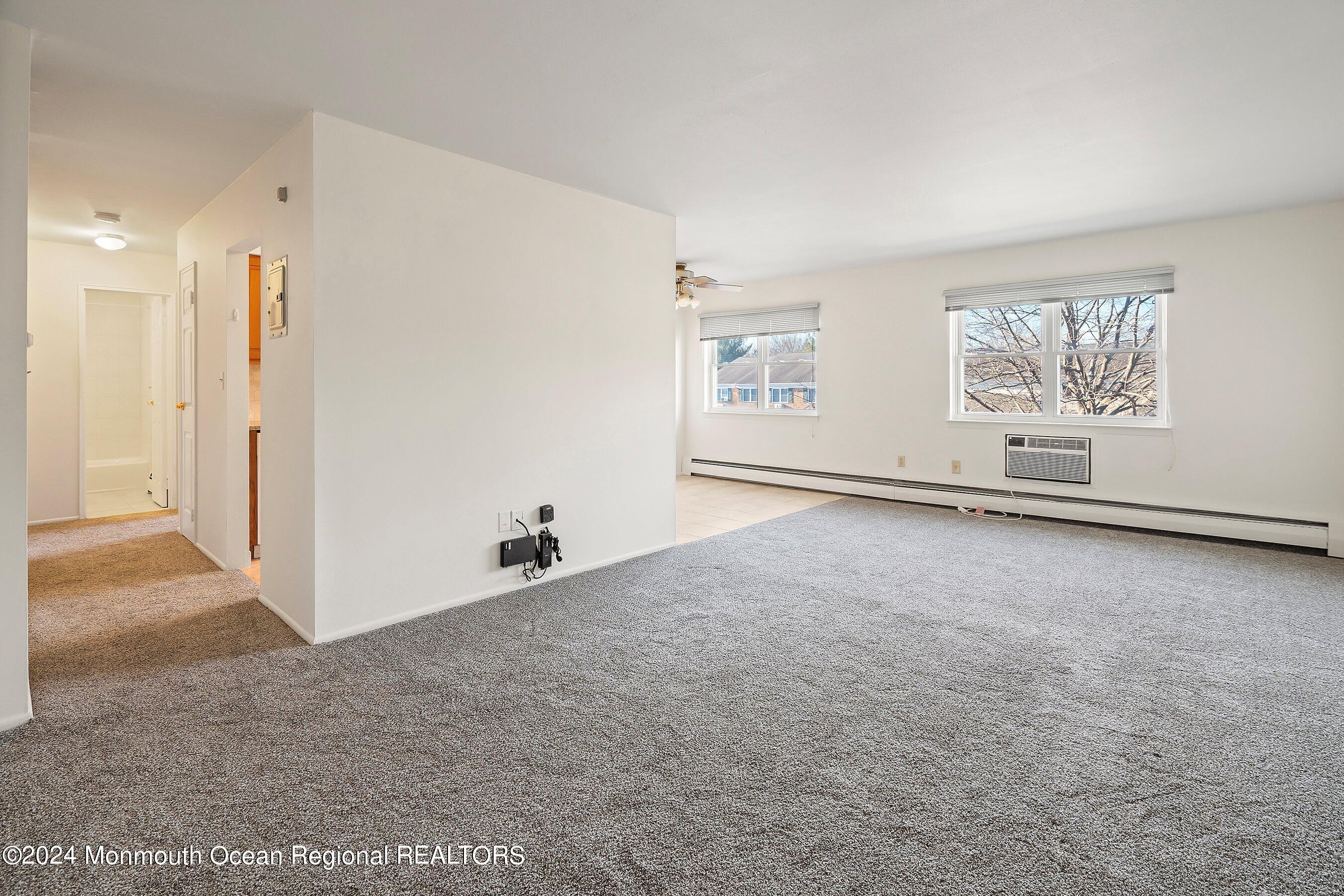 80 Manchester Court, Unit F Freehold, NJ 07728 - Photo 2 of 10 a view of a livingroom with an empty space and a window