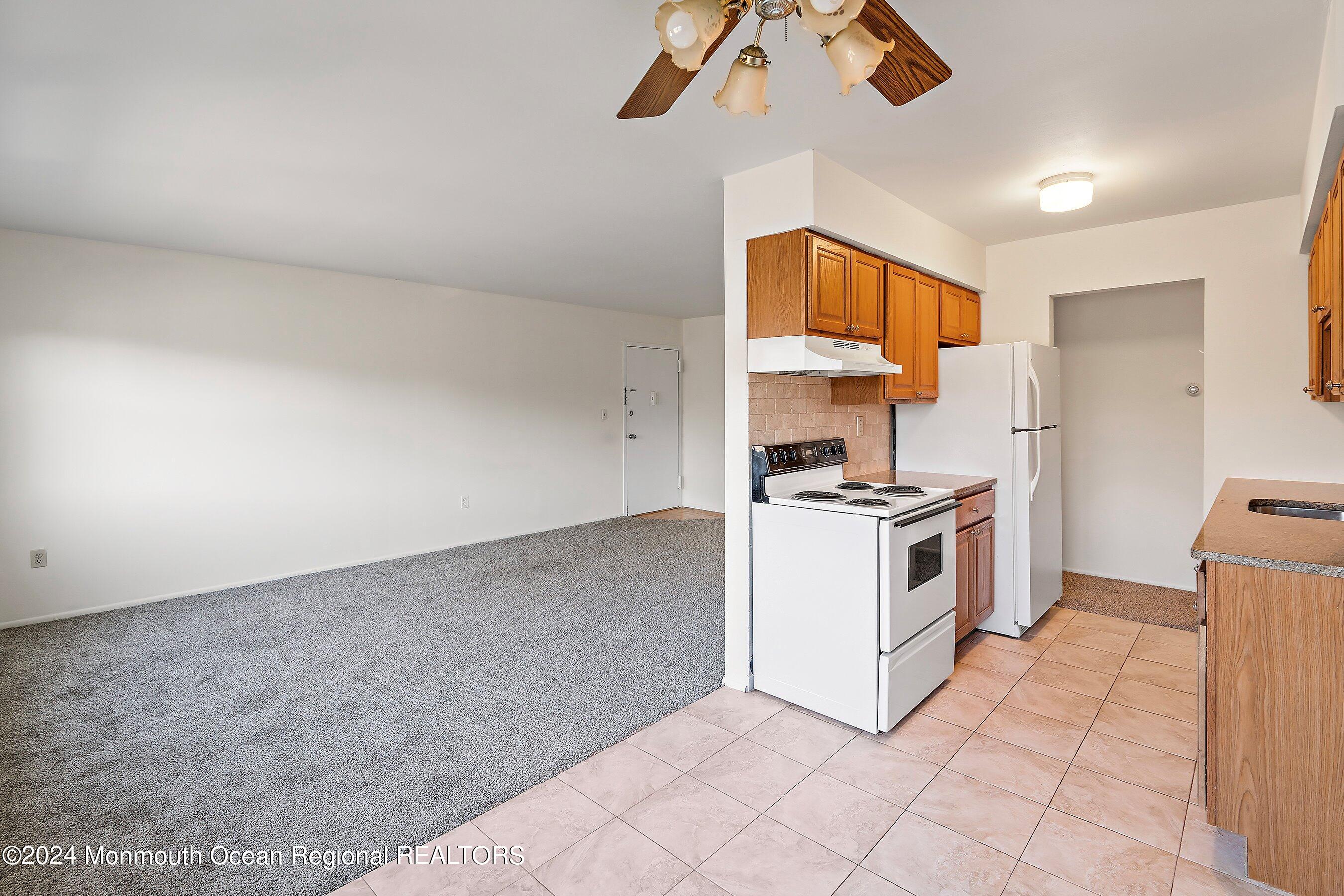 80 Manchester Court, Unit F Freehold, NJ 07728 - Photo 7 of 10 a kitchen with a white cabinets and white appliances
