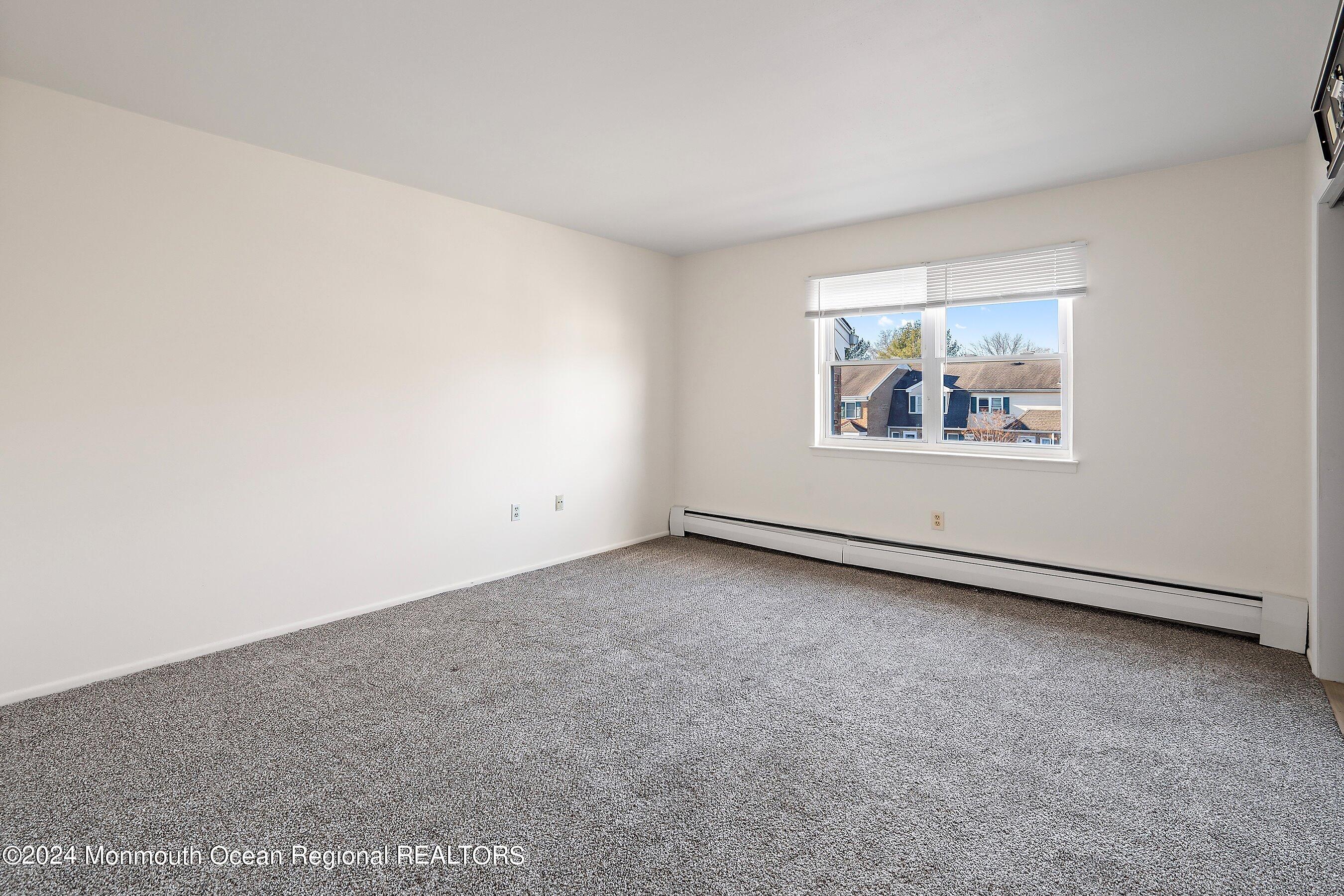 80 Manchester Court, Unit F Freehold, NJ 07728 - Photo 10 of 10 an empty room with windows