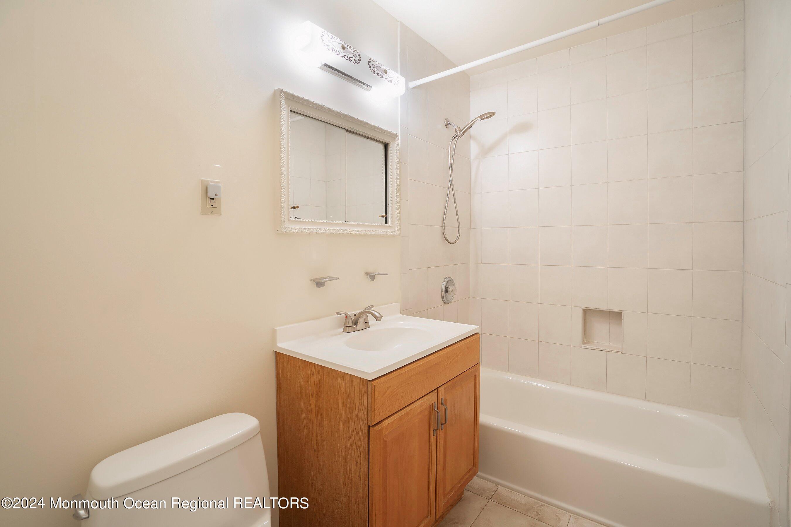 80 Manchester Court, Unit F Freehold, NJ 07728 - Photo 10 of 10 a bathroom with a sink a toilet and shower