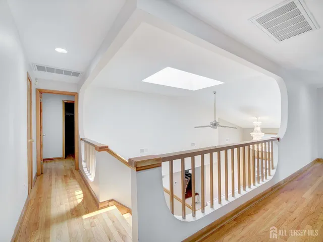 a view of a hallway with wooden floor and staircase