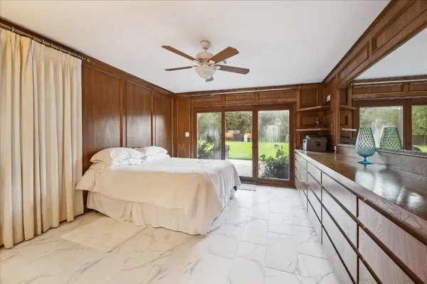 a bedroom with furniture and a large window