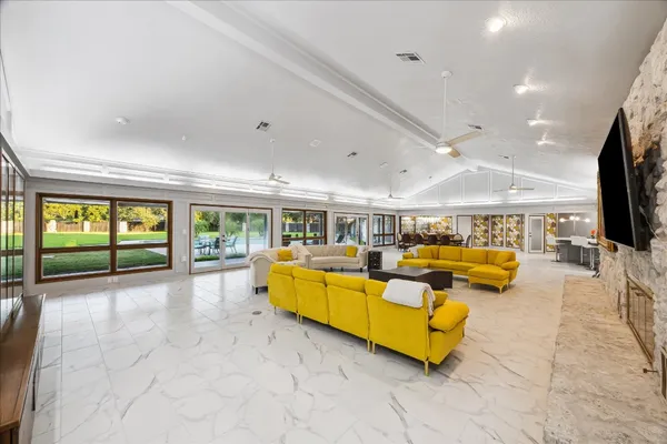 a living room with furniture fireplace and large windows