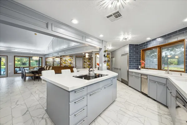 a large white kitchen with a large window