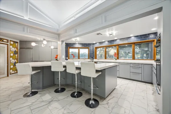 a kitchen with a sink and chairs