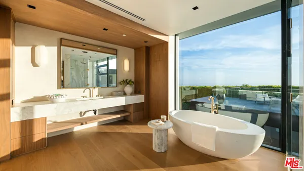 a large white tub sitting next to a bathroom sink