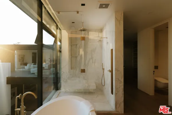 a bathroom with a tub shower vanity and a sink