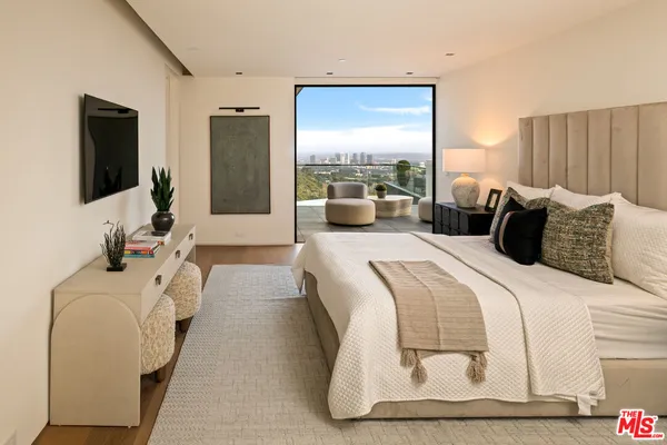 a bedroom with a bed and large mirror