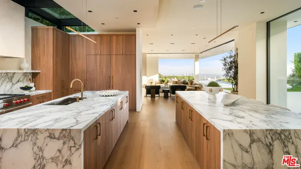 a large kitchen with kitchen island a sink stove and view of living room