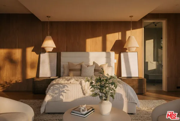 a bedroom with a large bed and a chandelier