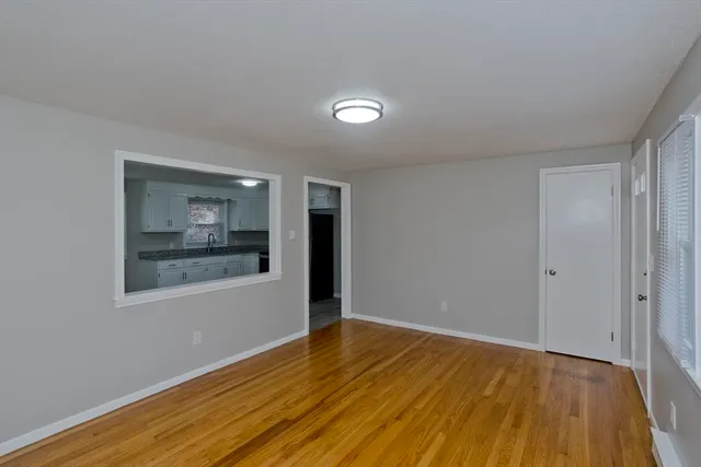 a view of a room with wooden floor and window