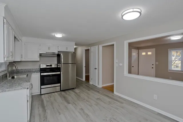 a kitchen with stainless steel appliances granite countertop a stove refrigerator and dining table