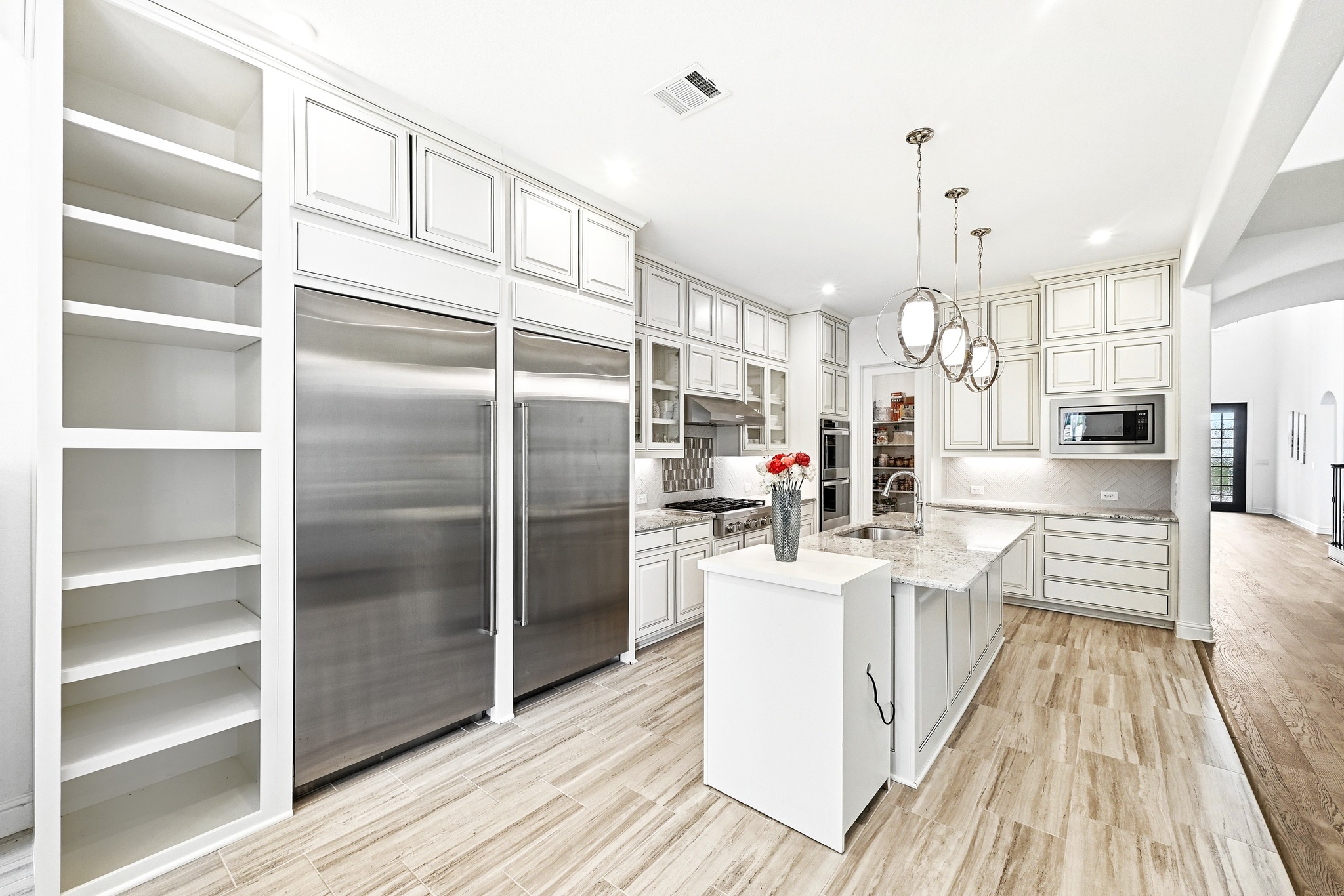 4601 Apollonia Way Leander, TX 78641 - Photo 6 of 40 a kitchen with stainless steel appliances kitchen island granite countertop a refrigerator a stove and white cabinets with wooden floor