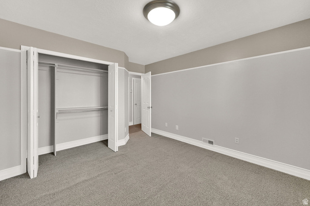 4792 Glasmann Way South Ogden, UT 84403 - Photo 50 of 70 Bedroom #2 interior room featuring neutral gray carpeting and light gray walls with a beige accent band and custom shelving