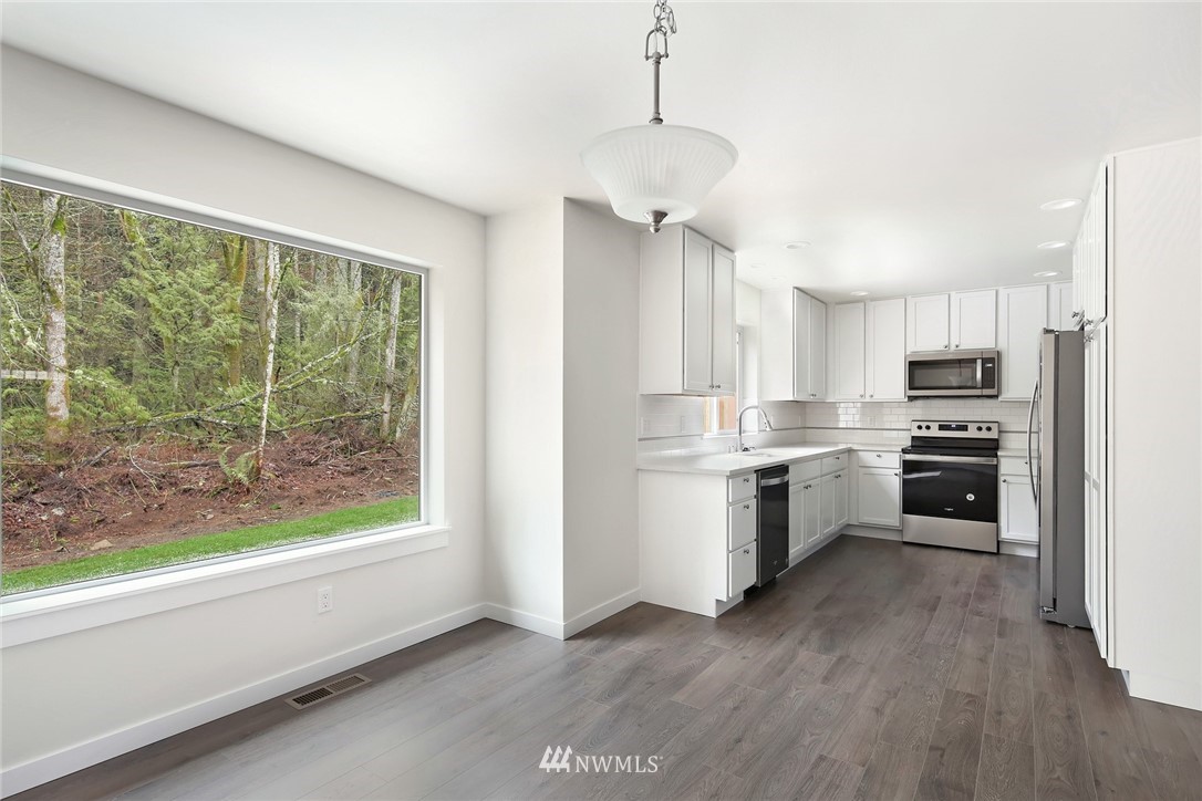 319 Whitetail Loop Blaine, WA 98230 - Photo 12 of 40 a kitchen with a refrigerator a stove a sink and a large window