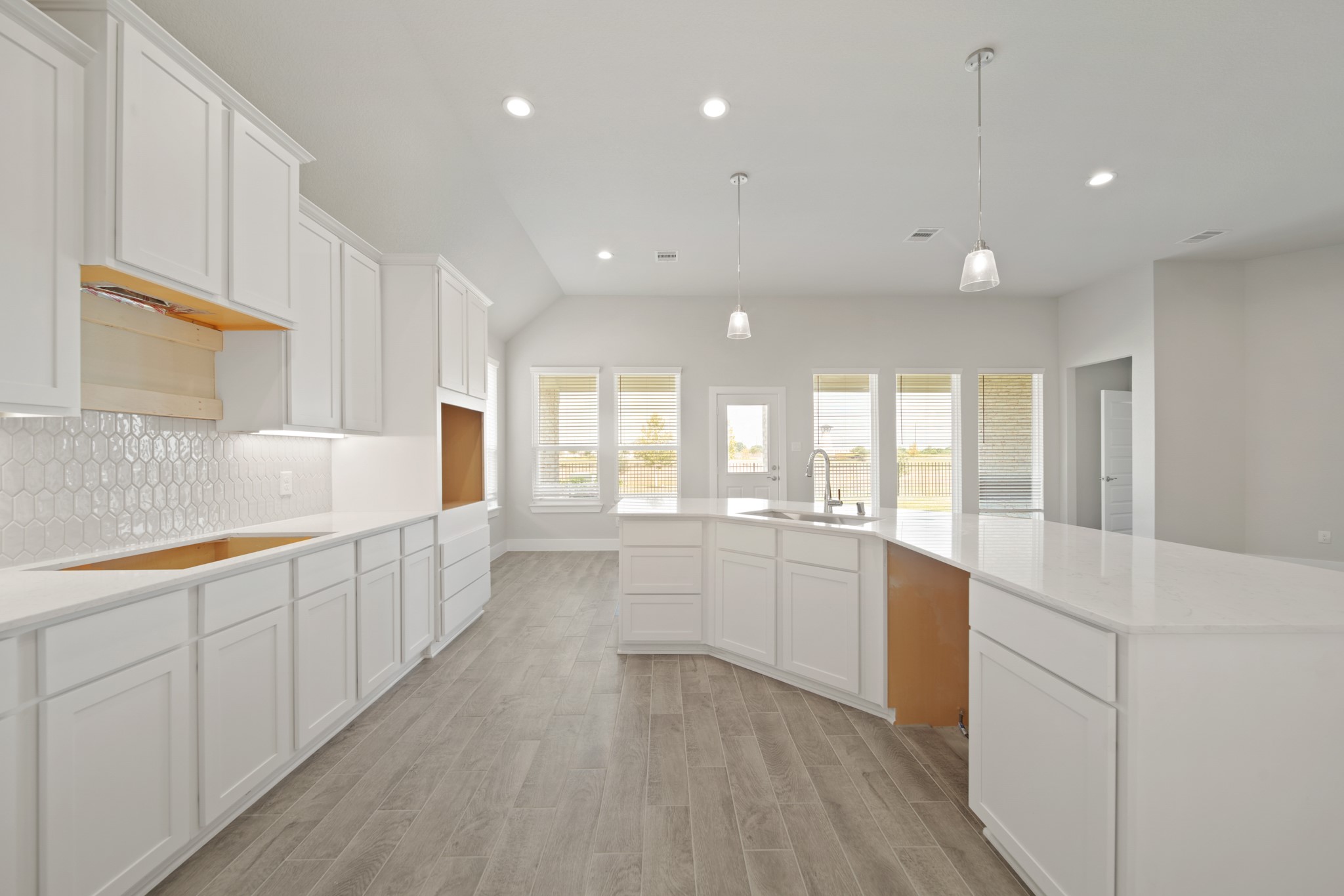 405 Hampton Edge Lane Waller, TX 77484 - Photo 6 of 45 a large white kitchen with lots of counter space and a sink