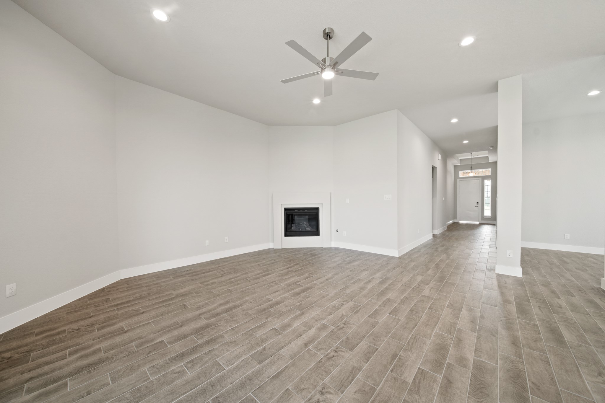 405 Hampton Edge Lane Waller, TX 77484 - Photo 10 of 45 an empty room with wooden floor and a ceiling fan