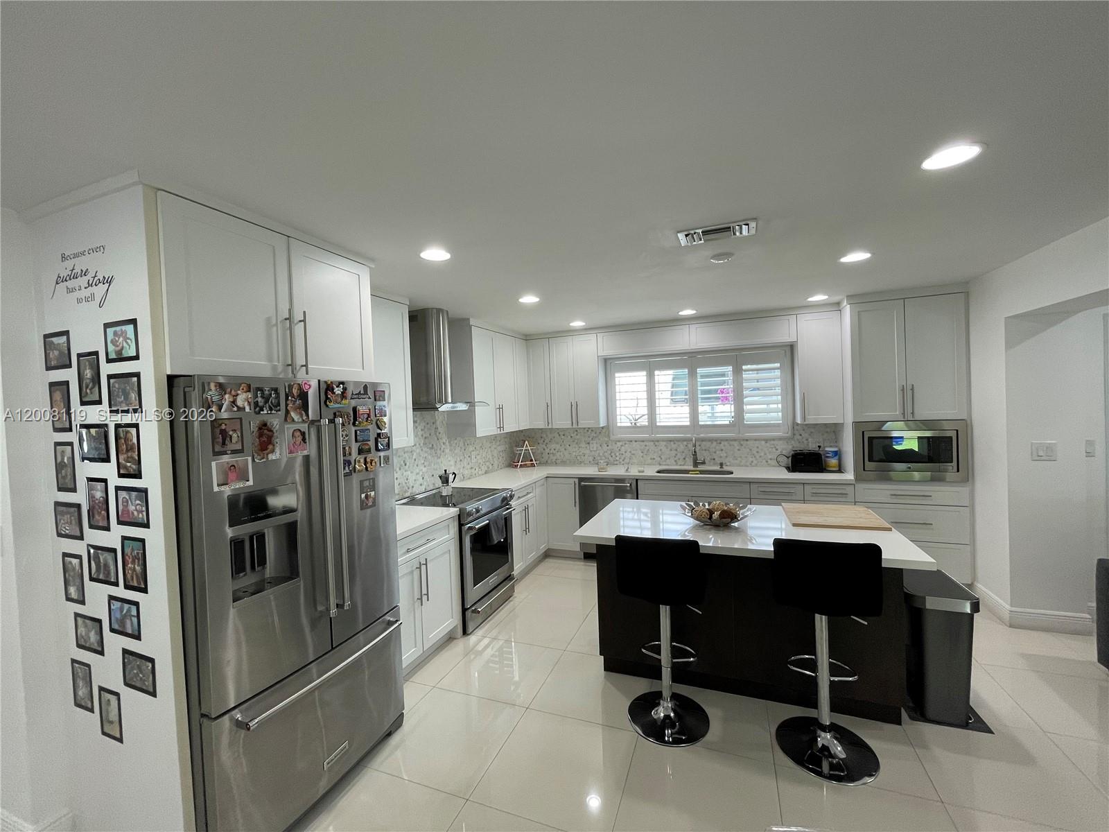 4161 Southwest 102nd Avenue Miami, FL 33165 - Photo 9 of 33 a kitchen with stainless steel appliances kitchen island granite countertop a refrigerator and a sink