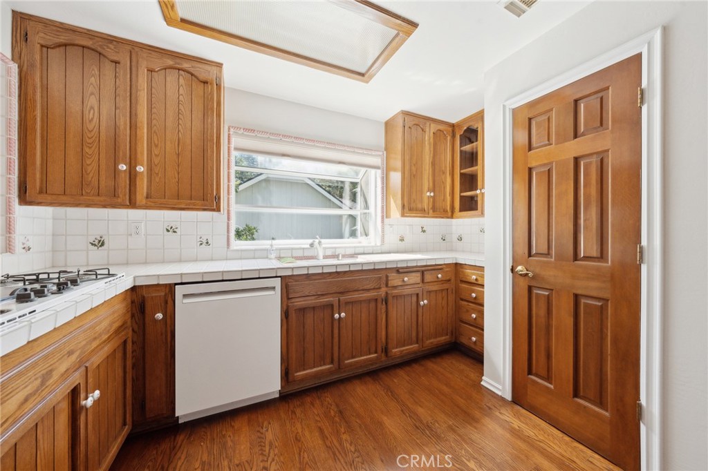 845 Sonoma Drive Lake Arrowhead, CA 92352 - Photo 15 of 49 a kitchen with stainless steel appliances granite countertop wooden cabinets a sink and dishwasher with wooden floor
