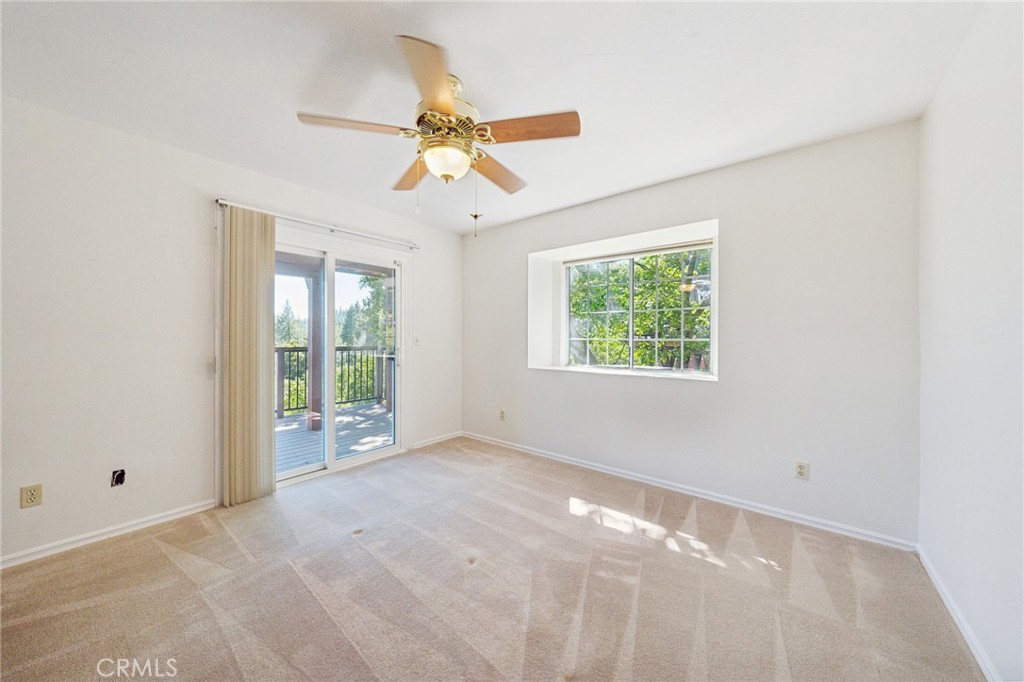 845 Sonoma Drive Lake Arrowhead, CA 92352 - Photo 23 of 49 an empty room with windows and chandelier fan