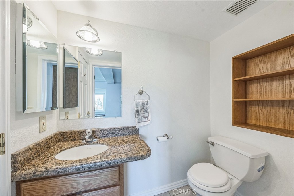 845 Sonoma Drive Lake Arrowhead, CA 92352 - Photo 32 of 49 a bathroom with a granite countertop toilet sink and mirror