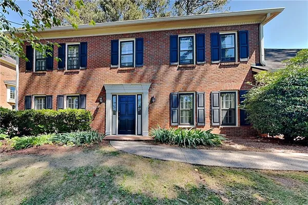 front view of a brick house with a yard