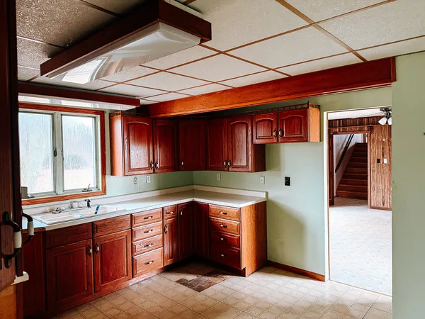 a kitchen with granite countertop wooden cabinets a sink and dishwasher